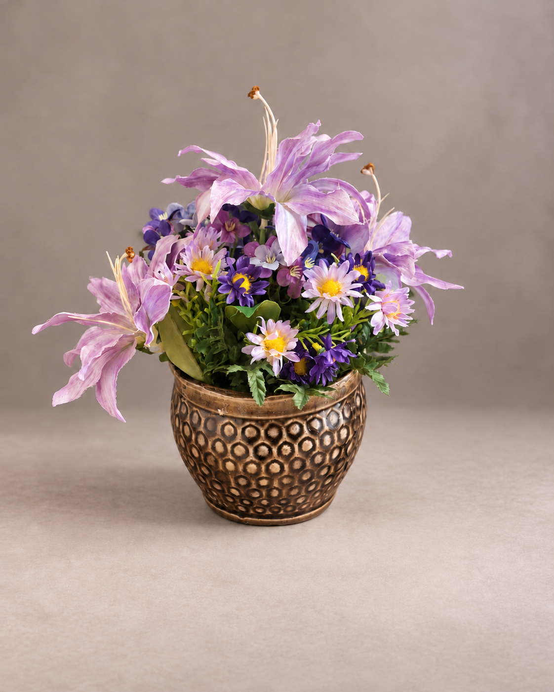 Purple lilies and daisies in a bronze patterned pot without props