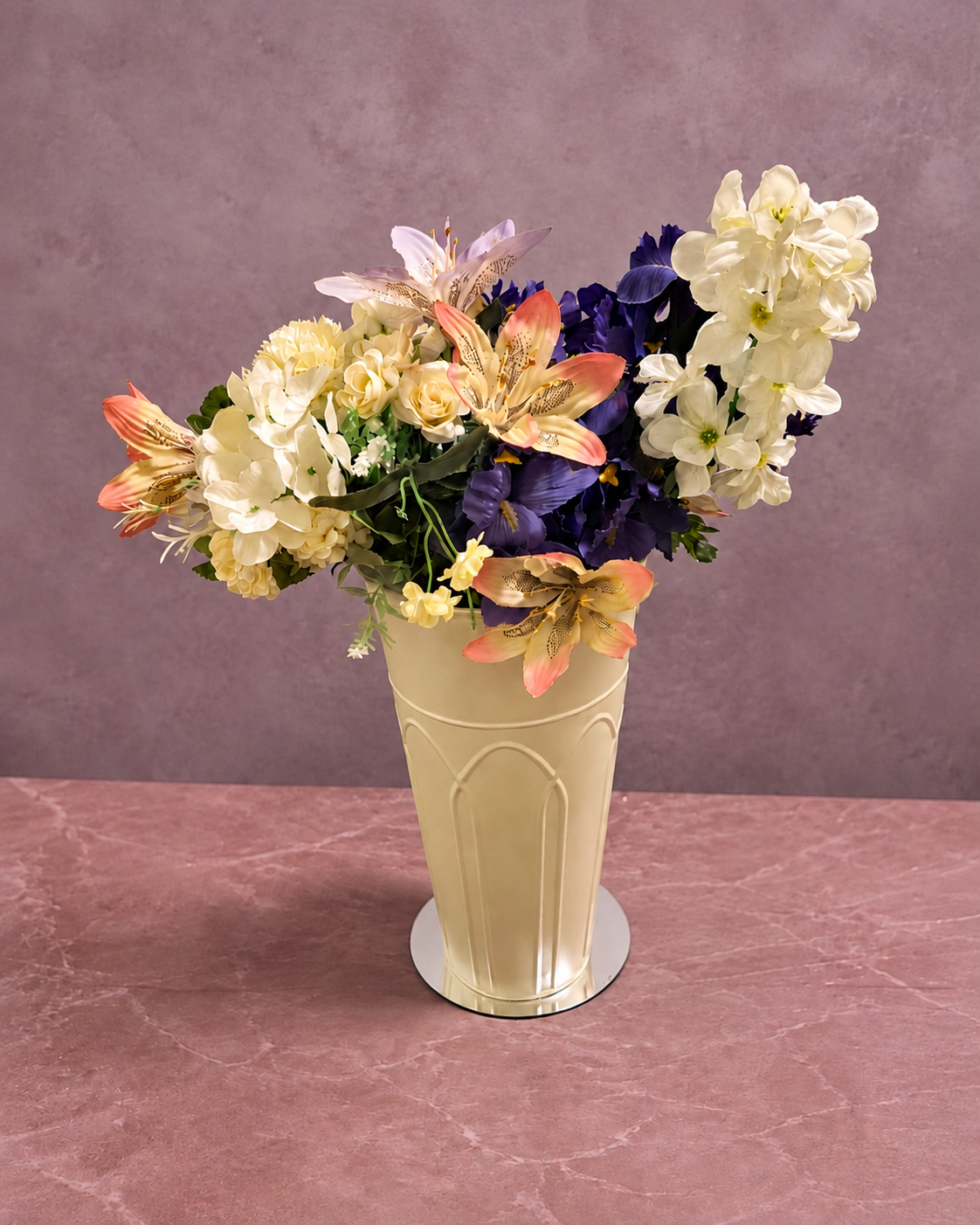 White, blush and purple flowers in a tall cream metal vase without props
