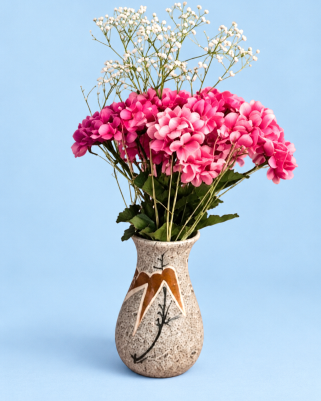 Pink flowers in a small speckled vintage vase against a light pastel blue background