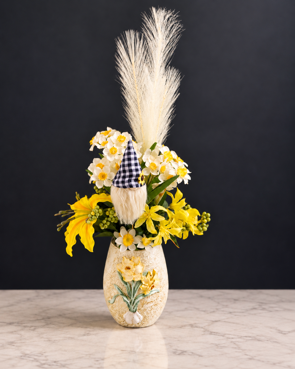 Yellow and white flowers with a checked-hat gnome and cream plumes in a floral vase