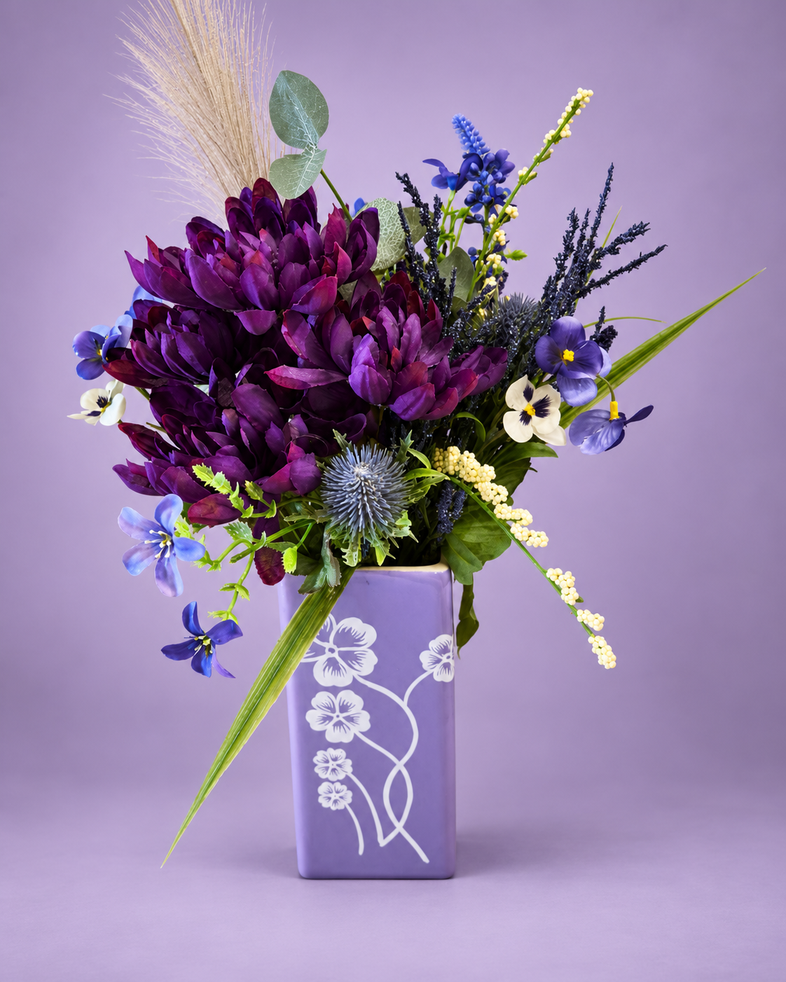 Purple flowers in a rectangular lavender vase with a white floral design